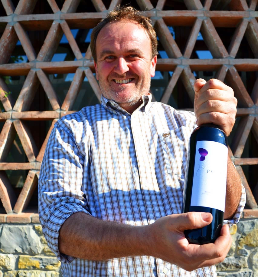 Daniele Cantalici holding a bottle of red wine